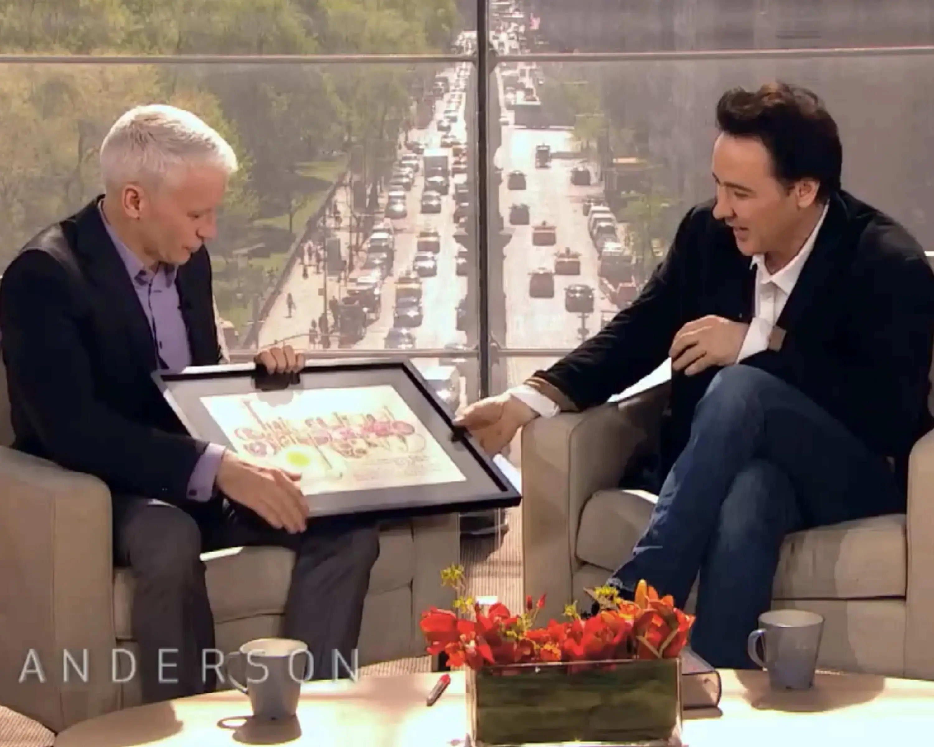 Celebrity television host Anderson Cooper presented movie actor John Cusack with a star gift from International Star Registry